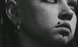 grayscale photo of woman with silver earrings