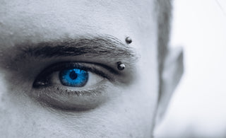 selective photo of man's blue eye