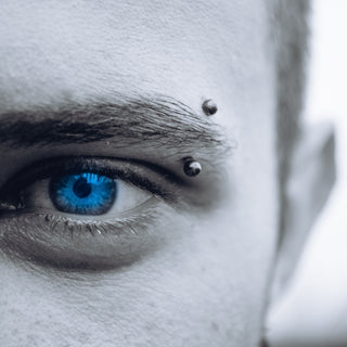 selective photo of man's blue eye