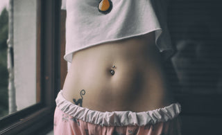 woman in white crop shirt with tattoo on her belly