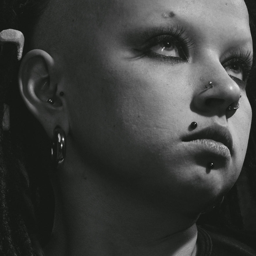 grayscale photo of woman with silver earrings