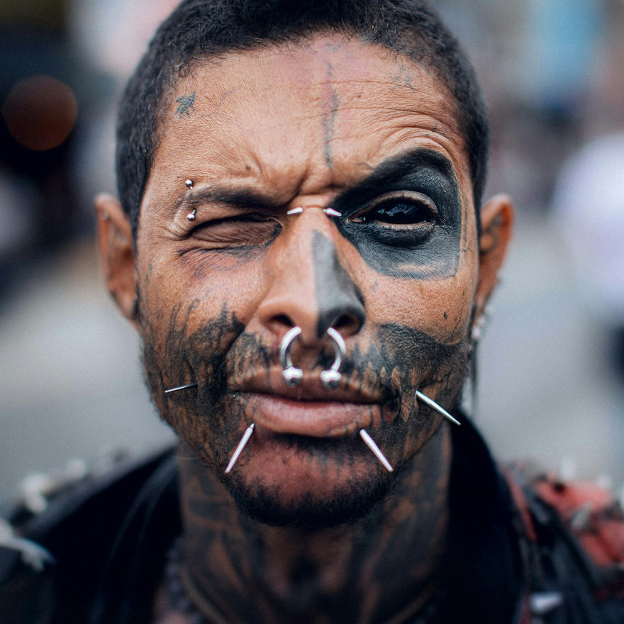 a man with black face paint and piercings on his nose
