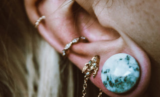 a close up of a person with ear piercings