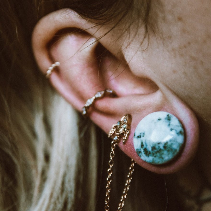 a close up of a person with ear piercings