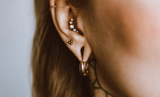 a woman with a tattoo on her neck and behind her ear