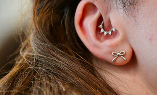 A close up of a person wearing a pair of ear piercings