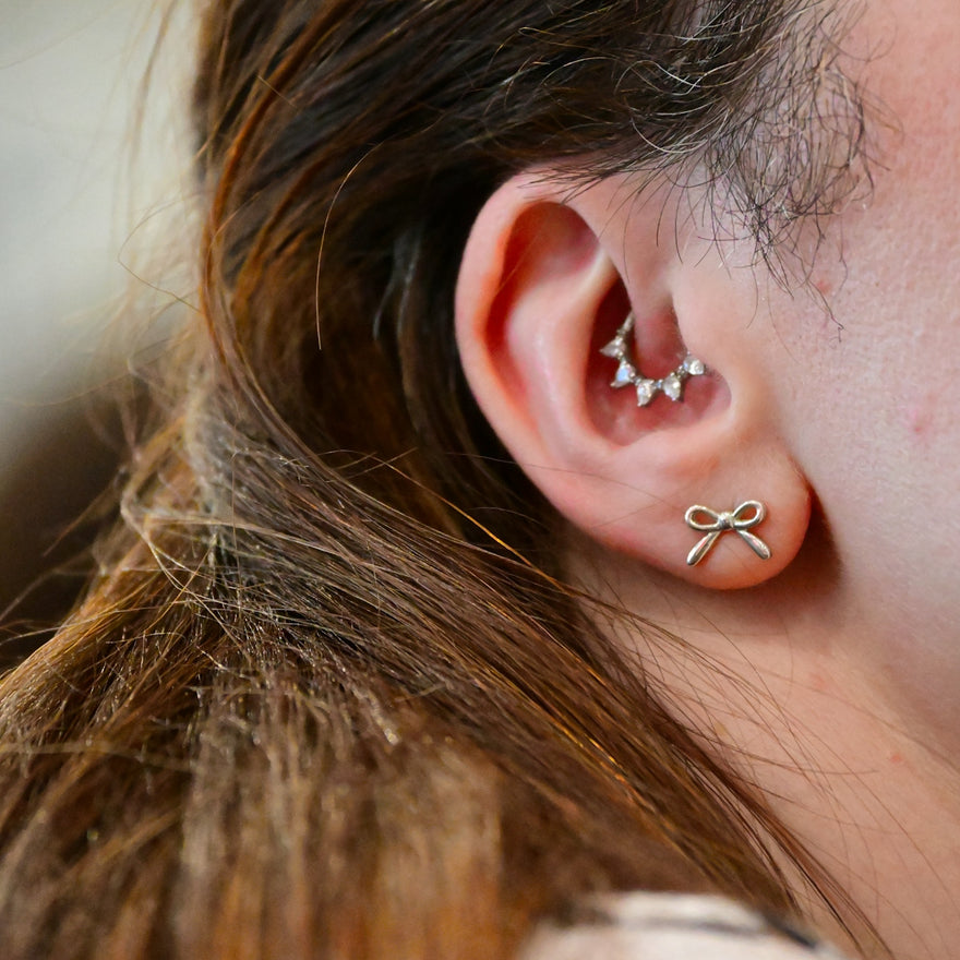 A close up of a person wearing a pair of ear piercings