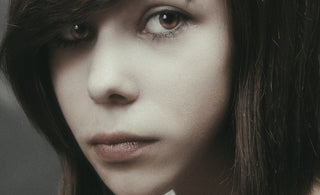 A young woman with dark hair gazes intently.