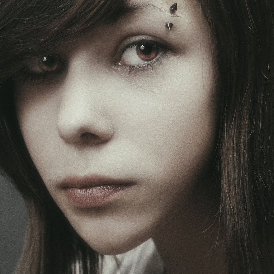 A young woman with dark hair gazes intently.