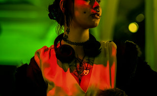 Woman with headphones and tattoos in red and green light