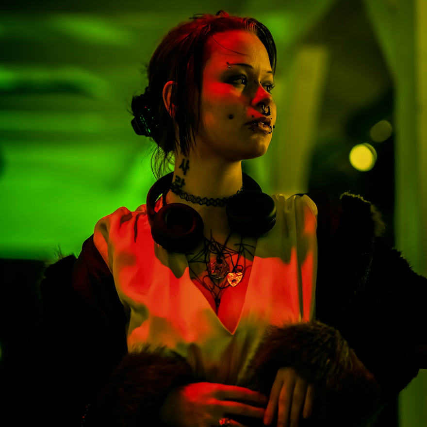 Woman with headphones and tattoos in red and green light