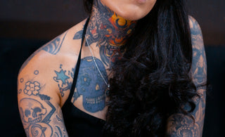 Woman with extensive tattoos and glasses