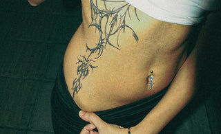 Woman showing a tribal tattoo on her stomach