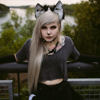 Young woman with wolf ears and grey hair outdoors
