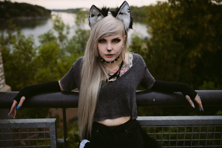 Young woman with wolf ears and grey hair outdoors