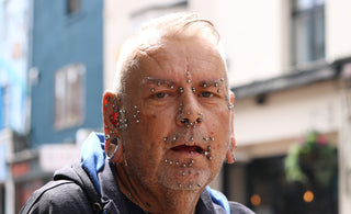 Elderly man with numerous facial piercings and jewelry
